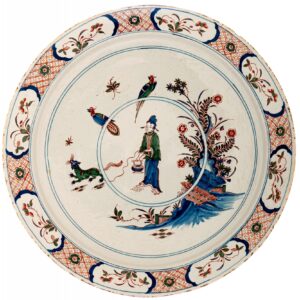 An exceptionally large Dutch Delftware charger decorated in the Cashmere palette of cobalt blue, green and iron red. The central scene depicts an Oriental figure in a stylised garden, accompanied by a striking green panther. Flowering plants and ornamental rockwork complete the chinoiserie composition.